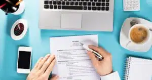 writing a resume with a laptop in front of them